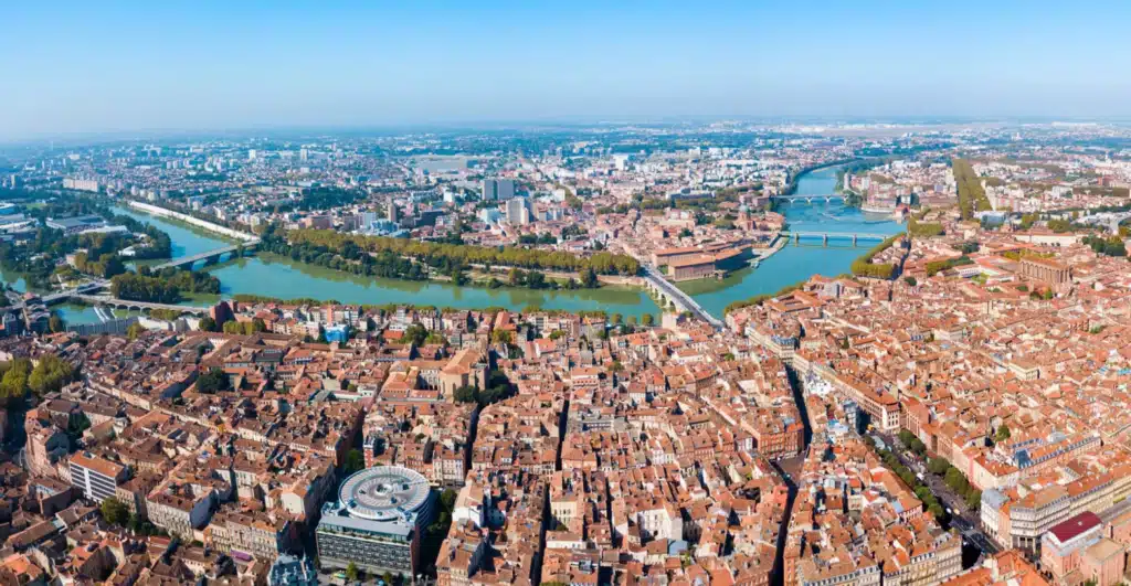 Toulouse Ville Rose : Panorama magnifique de la Garonne. Vue aérienne panoramique de Toulouse, la Ville Rose. La Garonne traverse l'architecture dense aux toits de tuiles rouges et aux ponts.